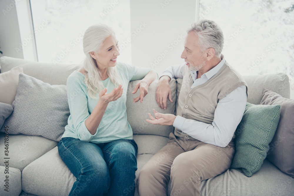 Photo of pretty aged pair communicating about social issues sitting cozy sofa indoors