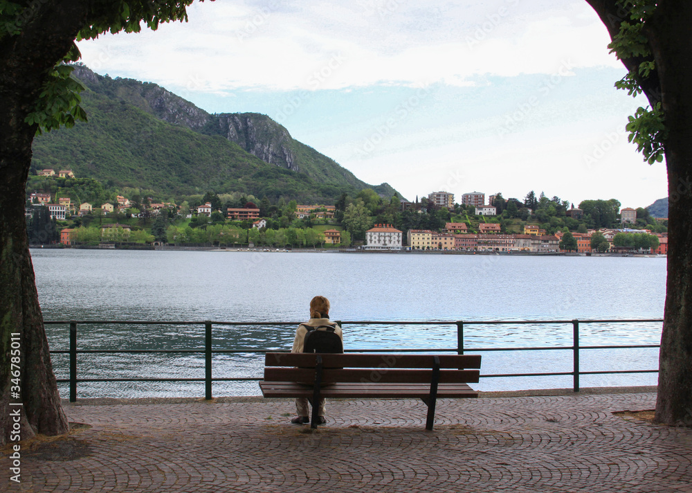 Tourist resting on bench looking at the lake