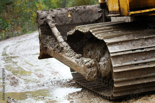 Crawler bulldozer rides on a dirt road photo