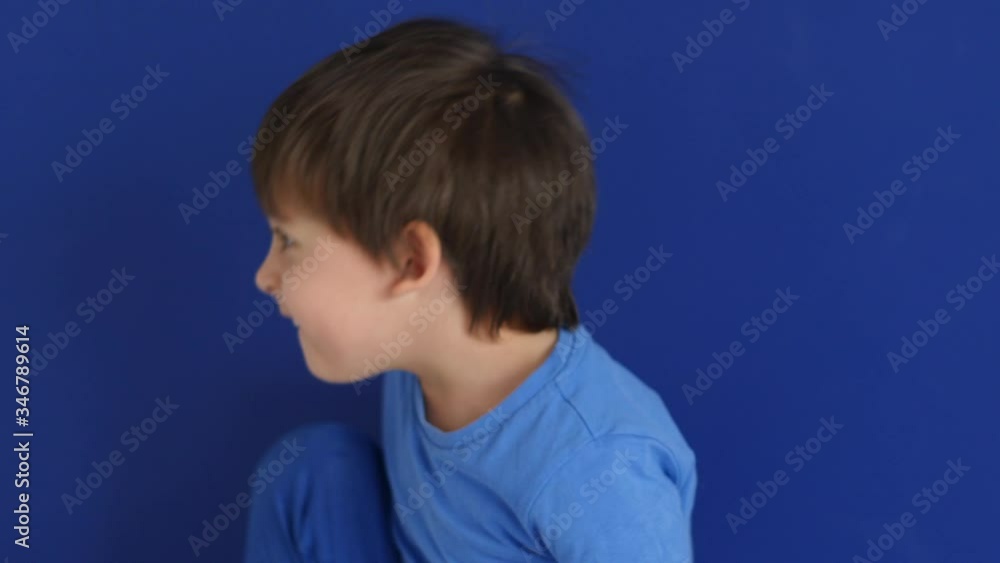 three-year-old child in blue pants and a T-shirt jumps on a white bed mattress against the wall in the apartment three-year-old child in blue pants and a T-shirt jumps on a white bed mattress against the wall in the apartment