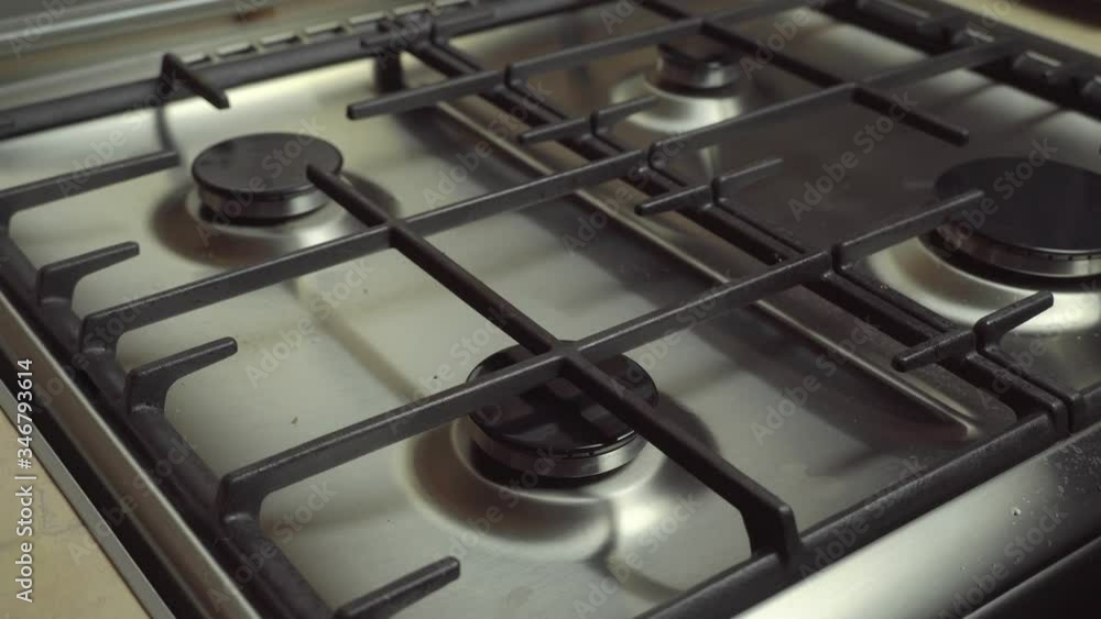 A person turns on a gas stove, oven, grill, and natural gas ignites burns with a blue flame, and then turns off. A person turns on a gas stove, oven, grill, and natural gas ignites burns with a blue flame, and then turns off.