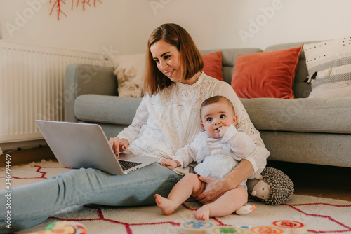 young business mother works from home with her cute baby
