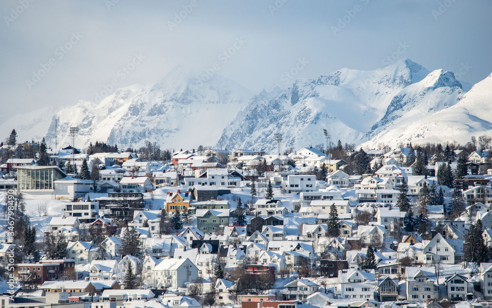 Parte de la ciudad de Tromso (Noruega) con una cadena montañosa tras ella.