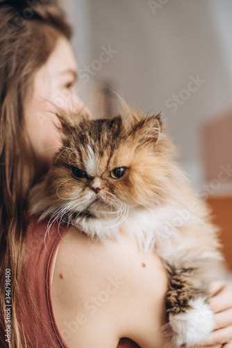 Beautiful young woman with cute cat resting at home