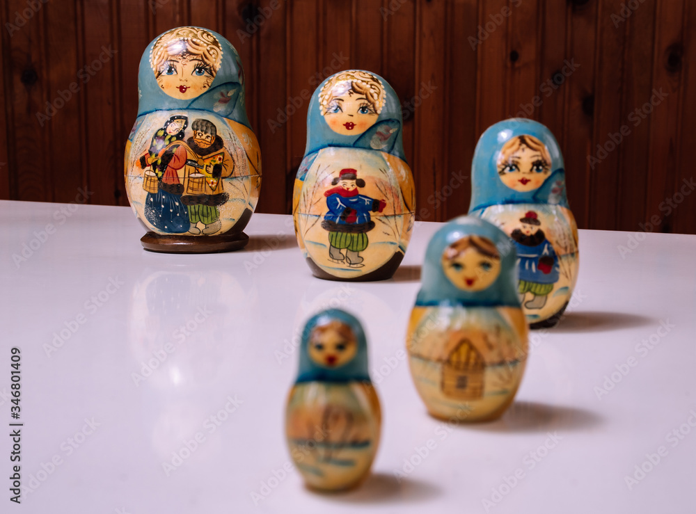 a set of babushka / matryoshka dolls perspective preferentially placed on the glossy white table a set of babushka / matryoshka dolls perspective preferentially placed on the glossy white table
