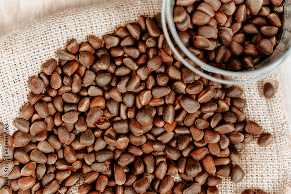 raw pine nuts spilled across the table. concept of harvesting in a small bucket raw pine nuts spilled across the table. concept of harvesting in a small bucket