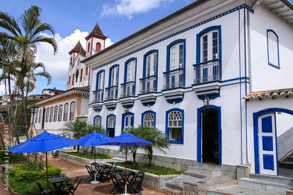 View to beautiful historic building and church, with palm trees and blue sky with white clouds, Serro, Minas Gerais, Brazil