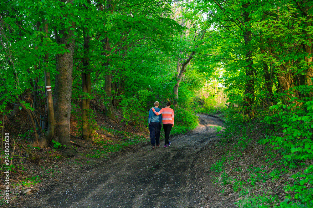 Man and woman spending time together in spring nature. Green landscape in evening time Man and woman spending time together in spring nature. Green landscape in evening time