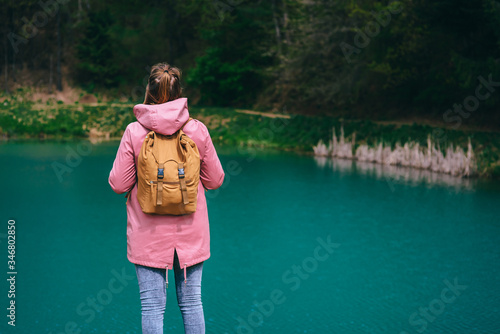 Adventure, travel, hiking concept photo. Woman and turquoise spring green lake