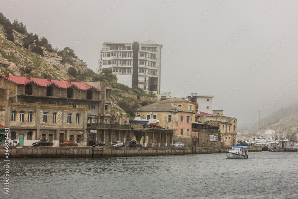 Crimea, Sevastopol, Balaklava district - 03/05/2017 : view of the houses from the bay on a foggy morning.