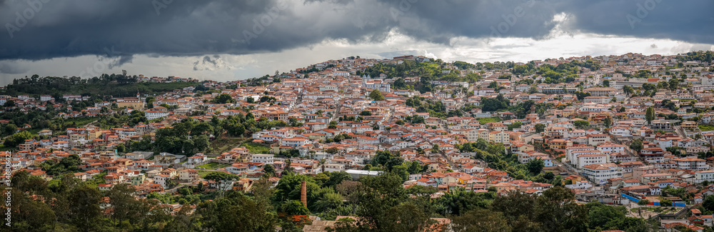 Panoramic aerial view with sunshine and dark cloudy sky of the historic town Diamantina nestled against the mountain, Minas Gerais, Brazil