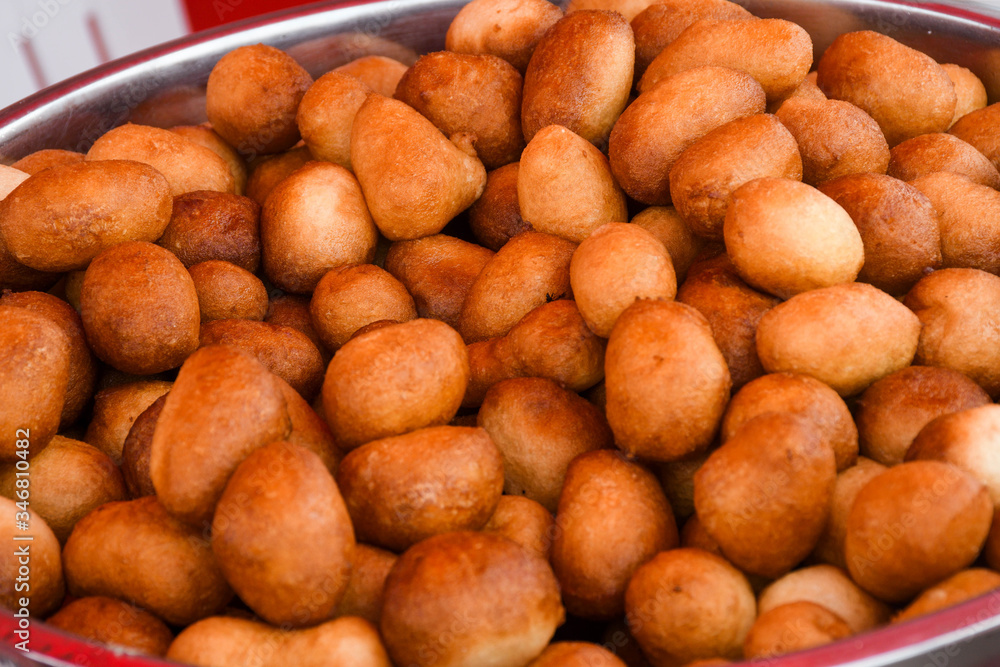 Fresh round small donuts during carnival or fast food festival, glazed with dark and white chocolate Fresh round small donuts during carnival or fast food festival, glazed with dark and white chocolate