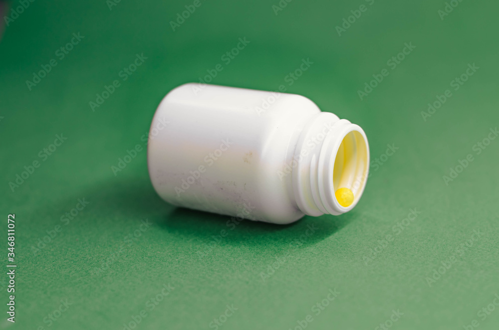 yellow vitamins in an open white packaging. yellow vitamins in an open white packaging.