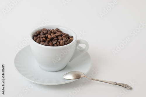 Cup оf coffee , white ceramic cup with roasted coffee beans on a white background. Isolate. Space for text