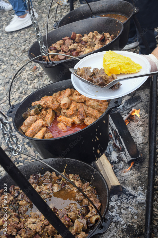 Very large cauldron cooking food during campfire. Cooking in a pot on the fire. Camping concept Very large cauldron cooking food during campfire. Cooking in a pot on the fire. Camping concept