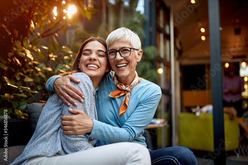 portrait of a senior mother and adult daughter, hugging, smiling. Love, affection, happiness concept