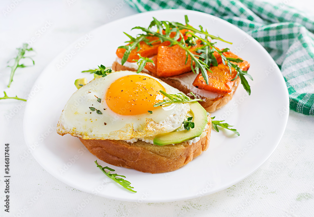 Healthy breakfast. Sandwich with avocado and fried egg, sandwich with fried sliced pumpkin for healthy breakfast or snack. Healthy breakfast. Sandwich with avocado and fried egg, sandwich with fried sliced pumpkin for healthy breakfast or snack.