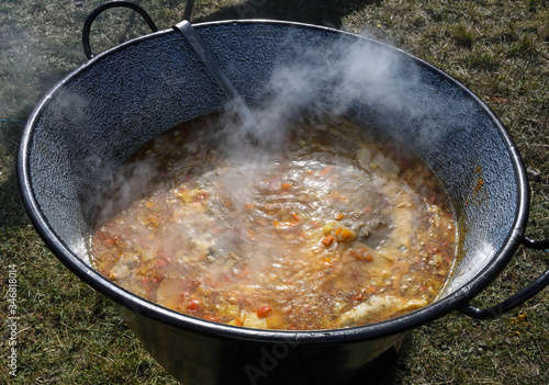 Very large cauldron cooking food during campfire. Cooking in a pot on the fire. Camping concept