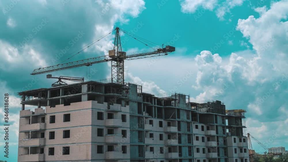 Time lapse of a working construction crane Building. Beautiful clouds move quickly against the background Time lapse of a working construction crane Building. Beautiful clouds move quickly against the background
