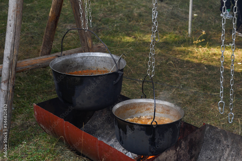 Very large cauldron cooking food during campfire. Cooking in a pot on the fire. Camping concept Very large cauldron cooking food during campfire. Cooking in a pot on the fire. Camping concept