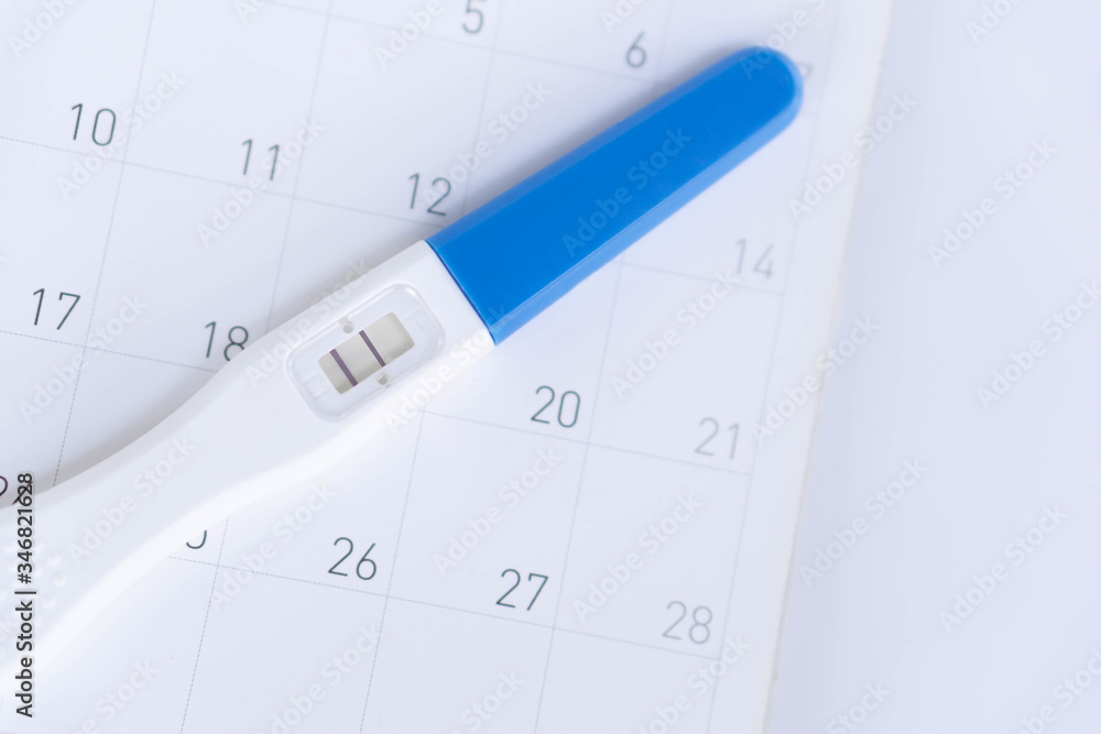 Pregnancy test on calendar background, health care concept Pregnancy test on calendar background, health care concept