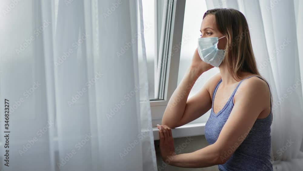 Pensive female in protective respirator having loneliness at home. Medium shot on RED camera Pensive female in protective respirator having loneliness at home. Medium shot on RED camera