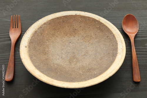 empty clay dish with wooden cutlery 