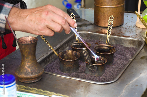 Turkish coffee reparation during street food festival, traditional specialty drink served