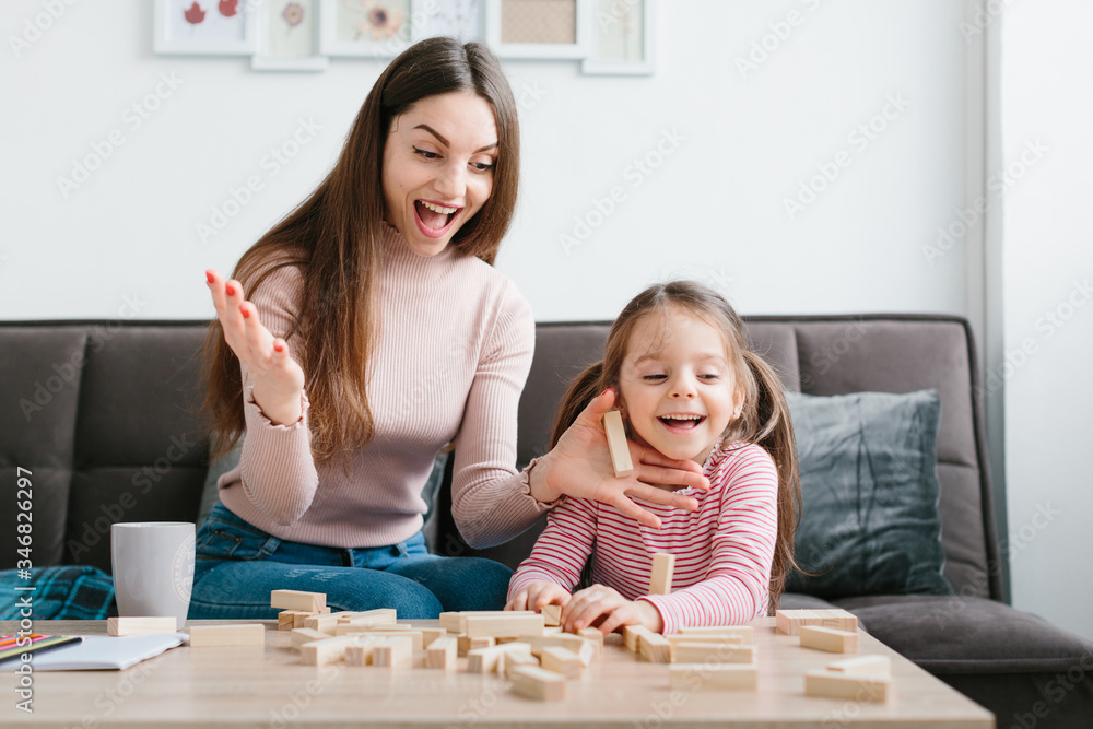 Mom and daughter play a board game in the living room. Mom and daughter play a board game in the living room.