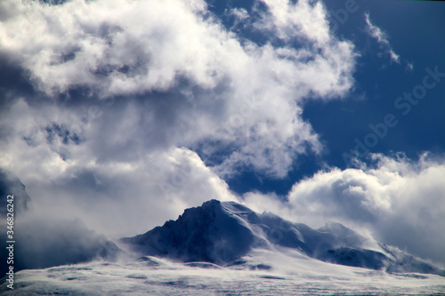 Plateau, high-voltage transmission tower, blue sky and white clouds, ice lake and distant Shishapangma Peak