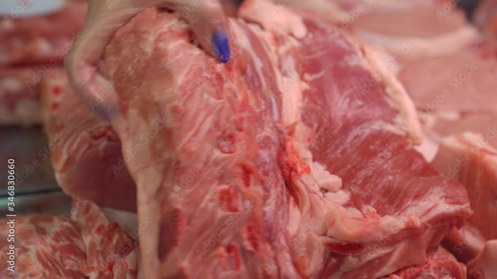 butcher. seller shows buyer meat of pork to choose