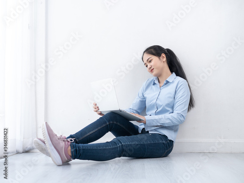 Happy Asian woman using laptop on the floor at home  work from home concept.
