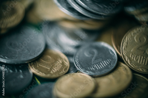 A macro shot of a large number of Ukrainian coins piled in chaos. Very shallow depth of field.