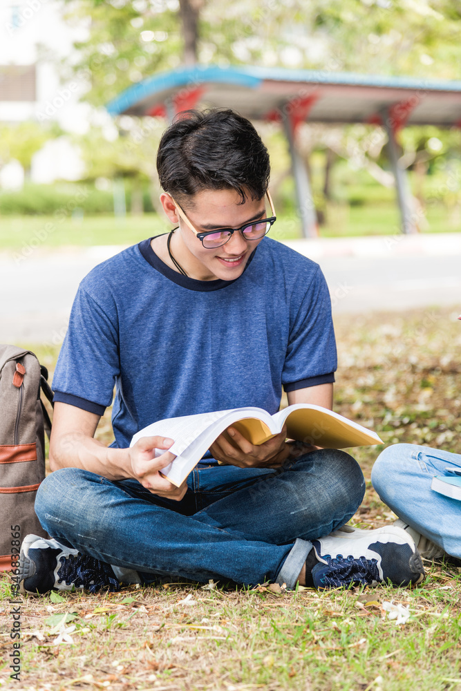 Obraz premium High angle young man university campus smiling students are during reading books college sitting outdoor with copy space, Education concept