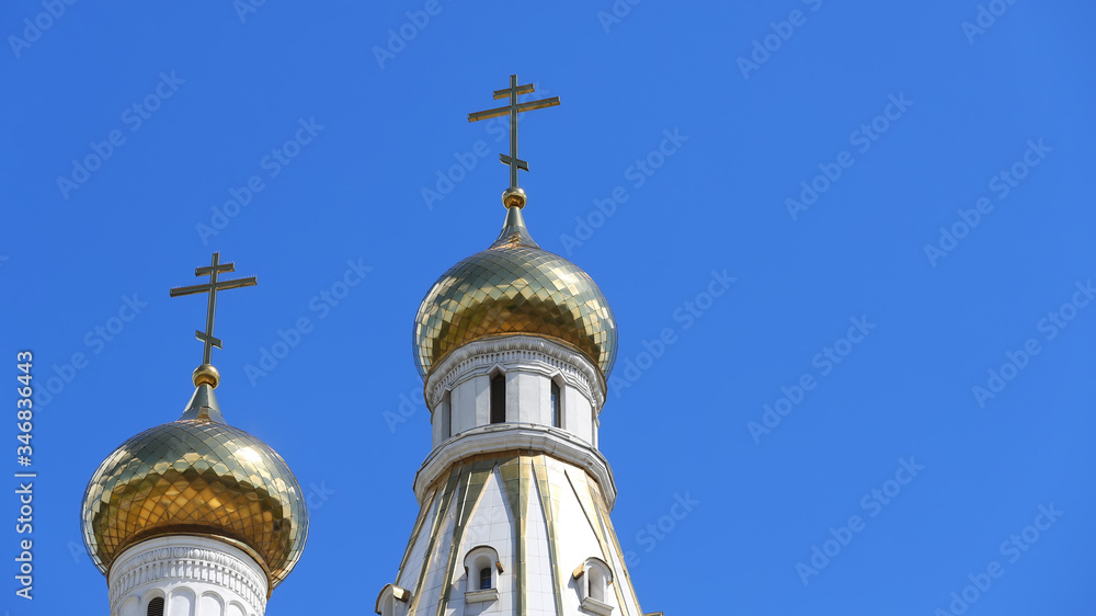 Close-up of the Orthodox golden cross on the roof of the Church against the background of blue sky