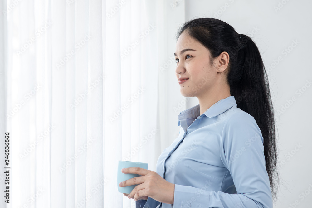 Asian business woman drinking coffee near window in the morning, lifestyle concept. Asian business woman drinking coffee near window in the morning, lifestyle concept.