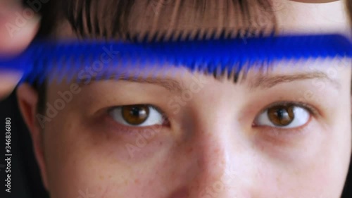 A woman cuts the hair on the head.Herself cut with scissors bangs.