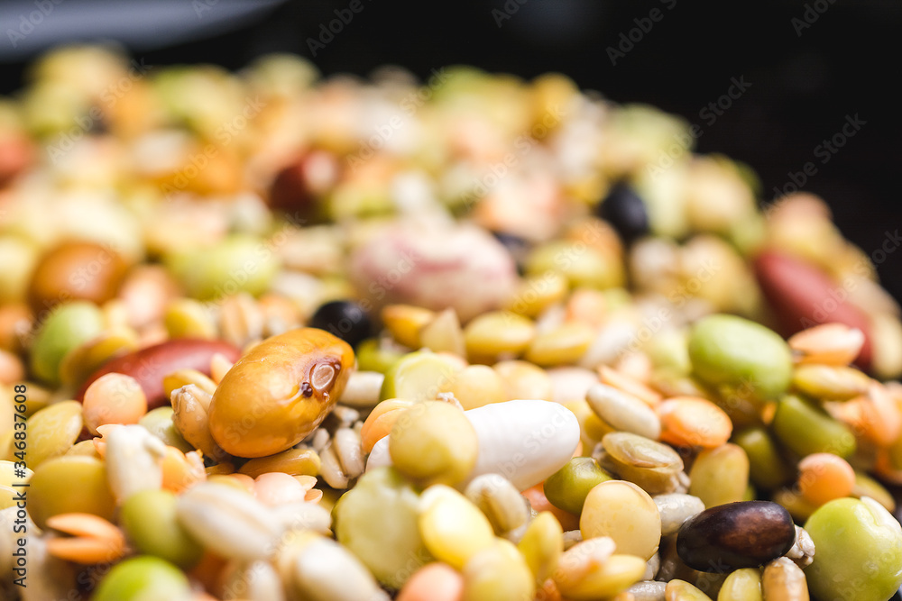Close up shot of different kind of legumes on a black reflective surface Close up shot of different kind of legumes on a black reflective surface