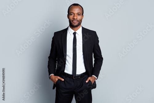 Portrait of confident intelligent afro american man marketer representative put hands pocket pants trousers ready decide successful solutions isolated over gray color background photo