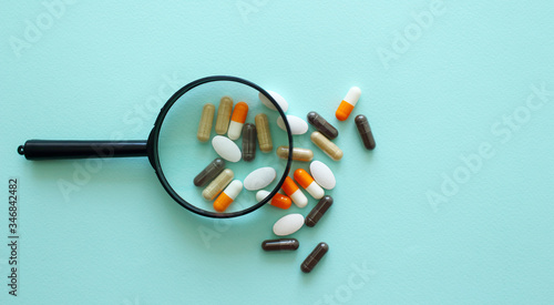 The pills under scrutiny.medicine, drug, vitamin, pharmacy,magnifier,concept