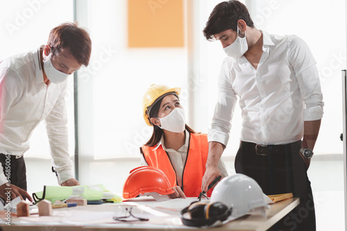 Group of creative building architect construction engineer project meeting and brainstorm together. Industry, Engineer, construction concept. Members wear face mask prevent covid-19 virus