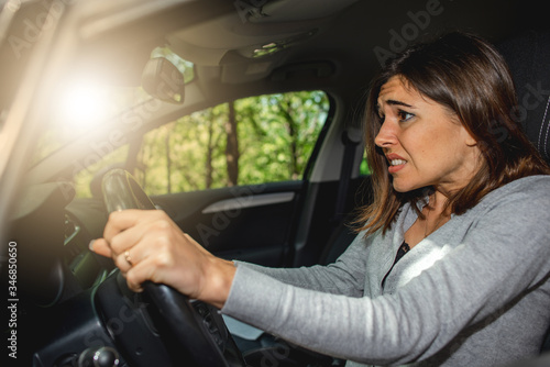 Fotografi Scared caucasian woman driving car and risking a car crash.