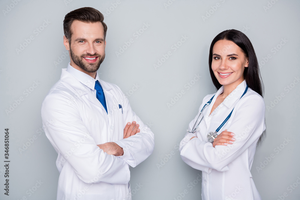 Photo of handsome doc guy professional lady patient consultation virology clinic listen client toothy smiling arms crossed experienced doctors wear lab coats isolated grey color background Photo of handsome doc guy professional lady patient consultation virology clinic listen client toothy smiling arms crossed experienced doctors wear lab coats isolated grey color background