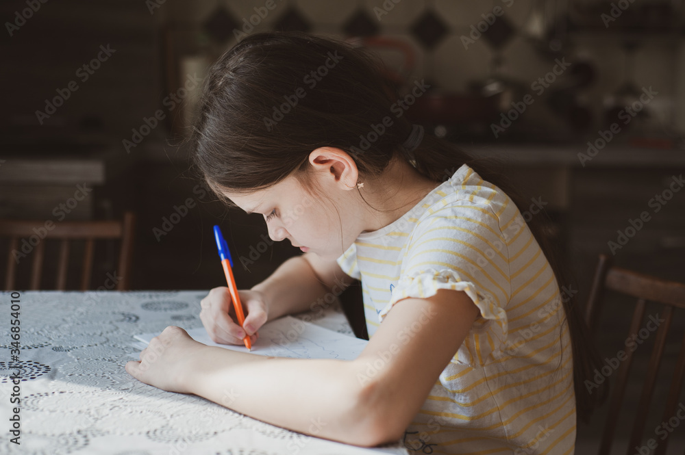 A teenager girl draws a pen in a sketchbook. Idea for quarantining a child A teenager girl draws a pen in a sketchbook. Idea for quarantining a child