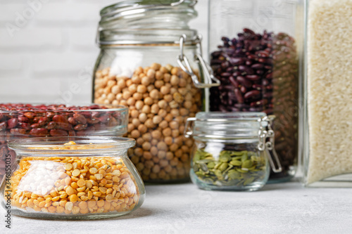 Raw cereals or beans in glass jars close up. Vegan and vegetarian food. Close up.