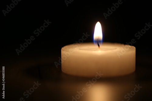 Selective focus close-up of memorial candle on black background