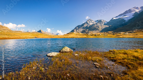 Sun is setting at Lej Pitschen, together with Lej Nair and Lago Bianco one of three lakes at The Bernina Pass. It connects Swiss Engadin valley with Val Poschiavo and ends in the Italian town Tirano