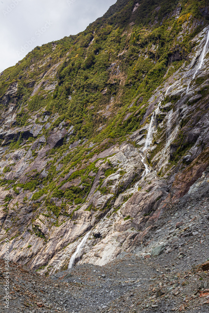 Stones, Ice and small waterfall. Franz Joseph Glacier. South Island, New Zealand Stones, Ice and small waterfall. Franz Joseph Glacier. South Island, New Zealand
