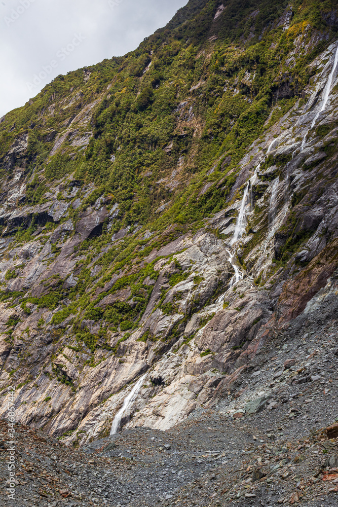 Stones, Ice and small waterfall. Franz Joseph Glacier. South Island, New Zealand