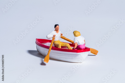 miniature figure concept of paddling the boat